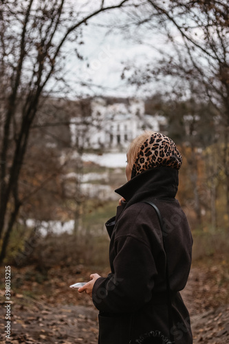 young woman in a leopard scarf in an autumn park and castle © YAROVA