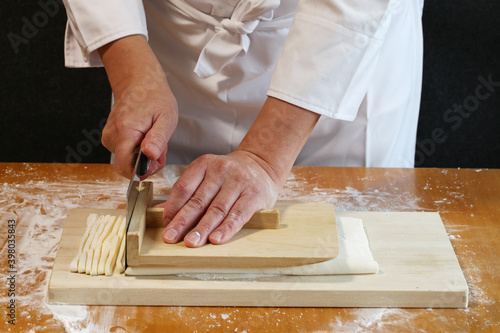 how to make japanese udon noodles; cut the rolled out dough with a knife.