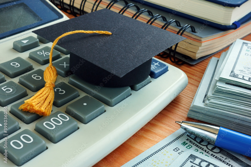 Φωτογραφία Student loan concept. Graduation cap on the calculator.