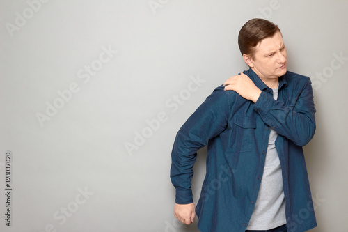 Studio shot of unhappy mature man suffering from pain in shoulder