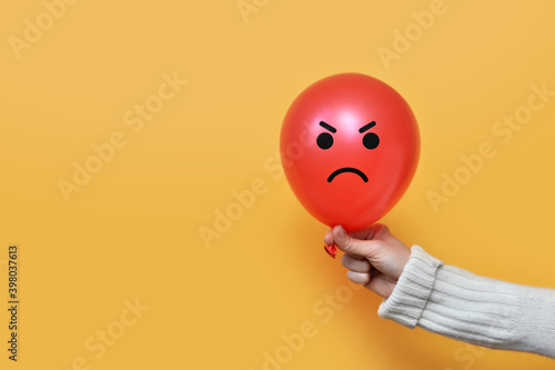 Print op canvas A balloon with an angry face in the hand of a man
