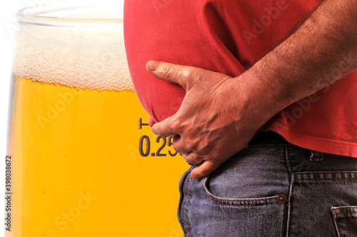 Concept d'obésité avec un homme au gros ventre et un verre de bière photo