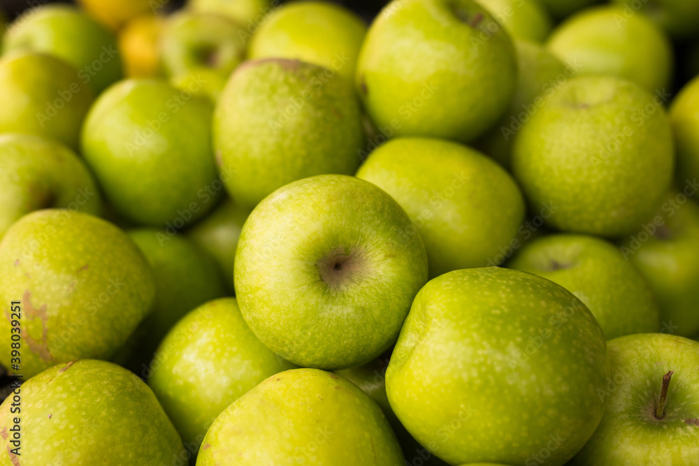 appetizing green apples on counter in market