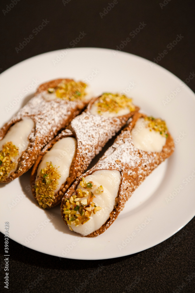 Cannoli are Italian pastries consisting of tube-shaped shells of fried pastry dough, filled with a sweet, creamy filling usually containing ricotta—a staple of Sicilian cuisine. Palermo, Sicily, Italy Cannoli are Italian pastries consisting of tube-shaped shells of fried pastry dough, filled with a sweet, creamy filling usually containing ricotta—a staple of Sicilian cuisine. Palermo, Sicily, Italy