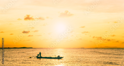 silhouette of a person on a boat at sunset sky over sea