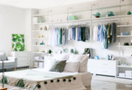 Big wardrobe with different clothes and accessories in modern bedroom