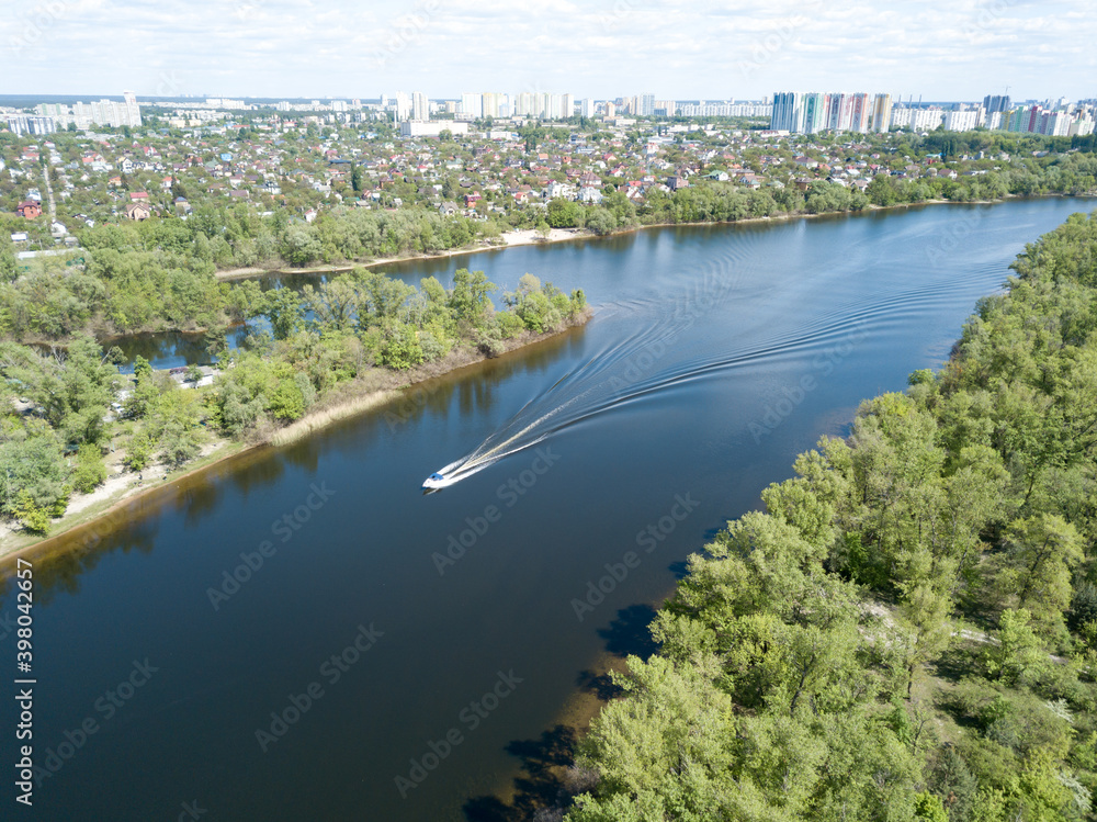 Aerial drone view. A motor boat sails down the river on a sunny day. Aerial drone view. A motor boat sails down the river on a sunny day.