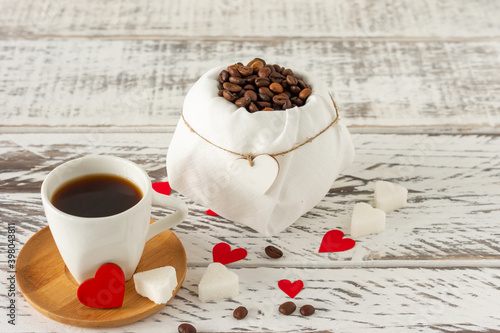 Festive St Valentines composition. Black romatic coffee with sugar in heart sashape and red scattered paper heart confetti