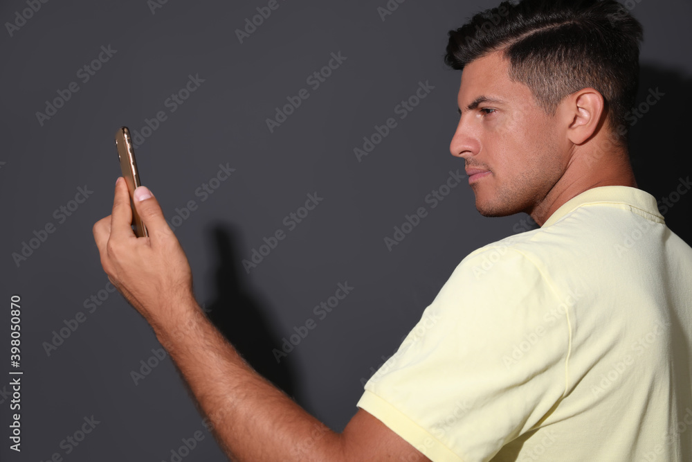 Man unlocking smartphone with facial scanner on grey background. Biometric verification Man unlocking smartphone with facial scanner on grey background. Biometric verification