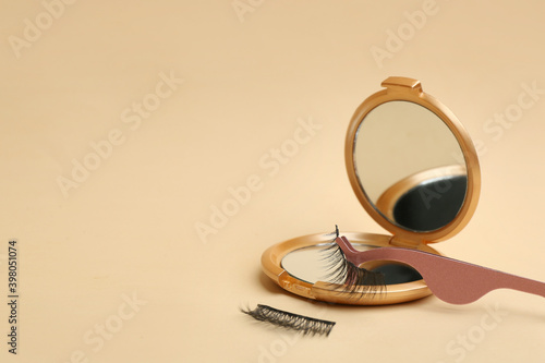 Magnetic eyelashes and accessories on beige background. Space for text