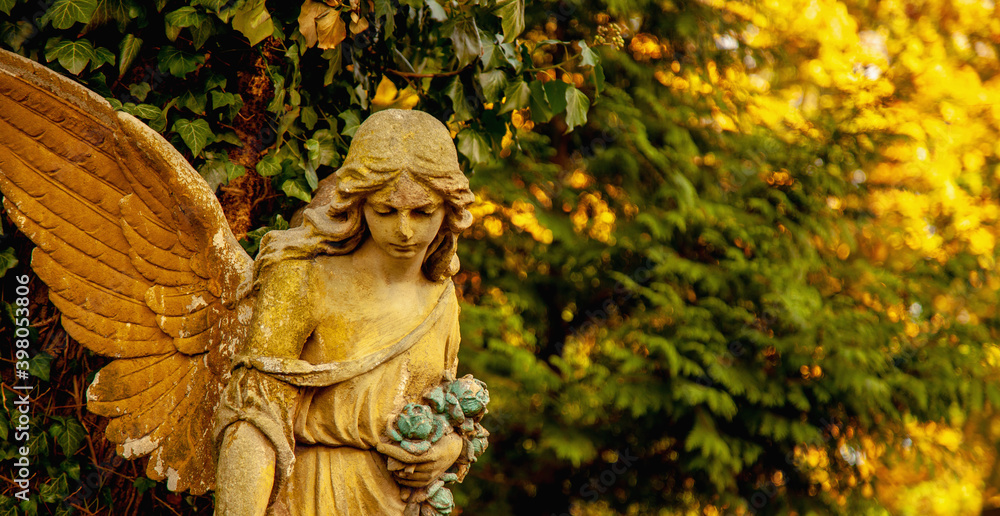 Guardian angel statue in sunlight. Free copy space for design or text. Horizontal image. Guardian angel statue in sunlight. Free copy space for design or text. Horizontal image.