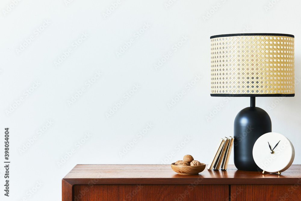 Scandinavian interior with stylish teak commode, design decoration, black rattan lamp, clock, copy space and elegant personal accessories. Modern living room in classic house. Template. Stock Photo | Adobe