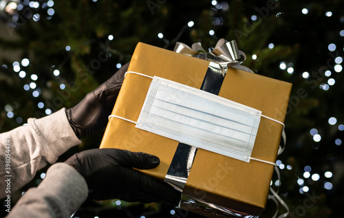 Obraz na płótnie gift box under the Christmas tree - medical mask - coronavirus pandemic | COVID-19 | Merry Christmas w salonie