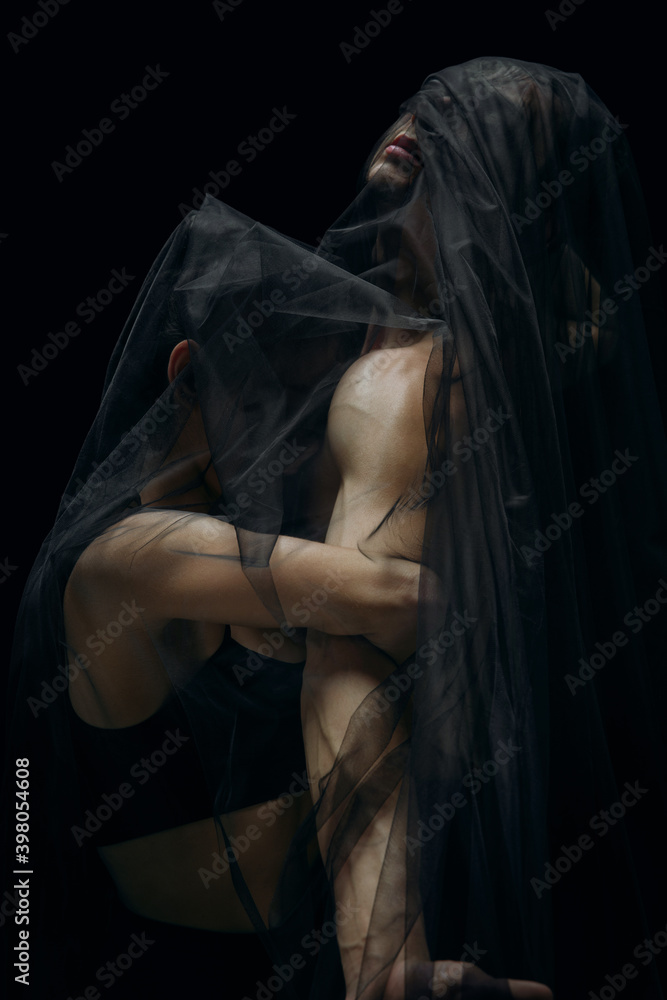 Mystery. Graceful classic ballet dancers isolated on black studio background. Couple in minimalistic dark cloth look graceful, inspired. The grace, artist, movement, action and motion concept. Mystery. Graceful classic ballet dancers isolated on black studio background. Couple in minimalistic dark cloth look graceful, inspired. The grace, artist, movement, action and motion concept.