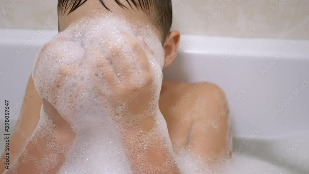 Boy Bathes in Bathroom, Plays with Bubbles of Soapy Foam, Makes Funny Foam Masks Boy Bathes in Bathroom, Plays with Bubbles of Soapy Foam, Makes Funny Foam Masks