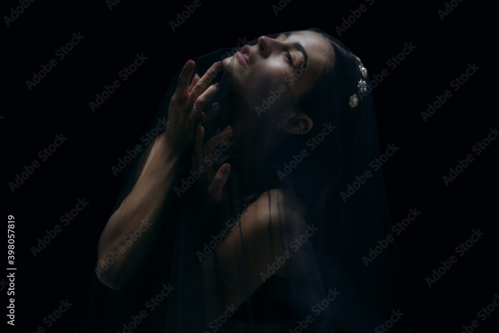 Loving. Graceful classic female ballet dancer isolated on black studio background. Woman in minimalistic black cloth looks graceful, inspired. The grace, artist, movement, action and motion concept. Loving. Graceful classic female ballet dancer isolated on black studio background. Woman in minimalistic black cloth looks graceful, inspired. The grace, artist, movement, action and motion concept.