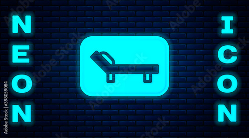 Glowing neon Sunbed icon isolated on brick wall background. Sun lounger. Vector.