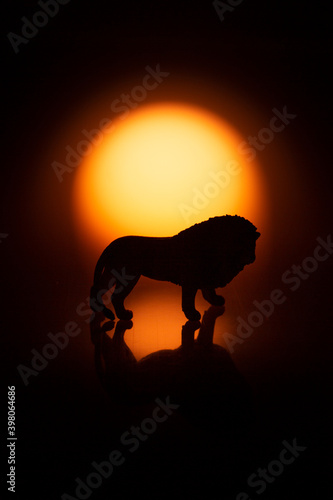 Silhouette de lion au coucher de soleil. Figurines.