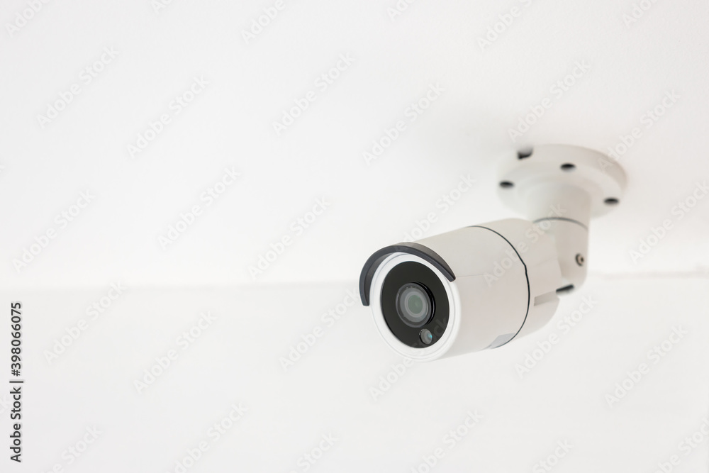 Security CCTV camera surveillance system indoor of house. A blurred night Cityscape background. Modern CCTV camera on a wall. Equipment system service for safety life or asset. Security CCTV camera surveillance system indoor of house. A blurred night Cityscape background. Modern CCTV camera on a wall. Equipment system service for safety life or asset.