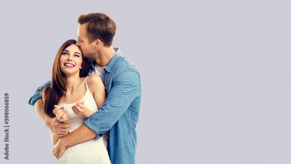 Naklejka premium Love, new parents and family concept - very happy excited couple, man and woman finding out results of pregnancy test. Isolated over grey background. Copy space.