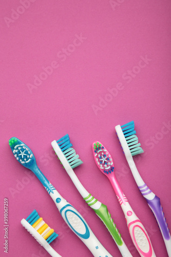 Toothbrushes on pink background with copy space.