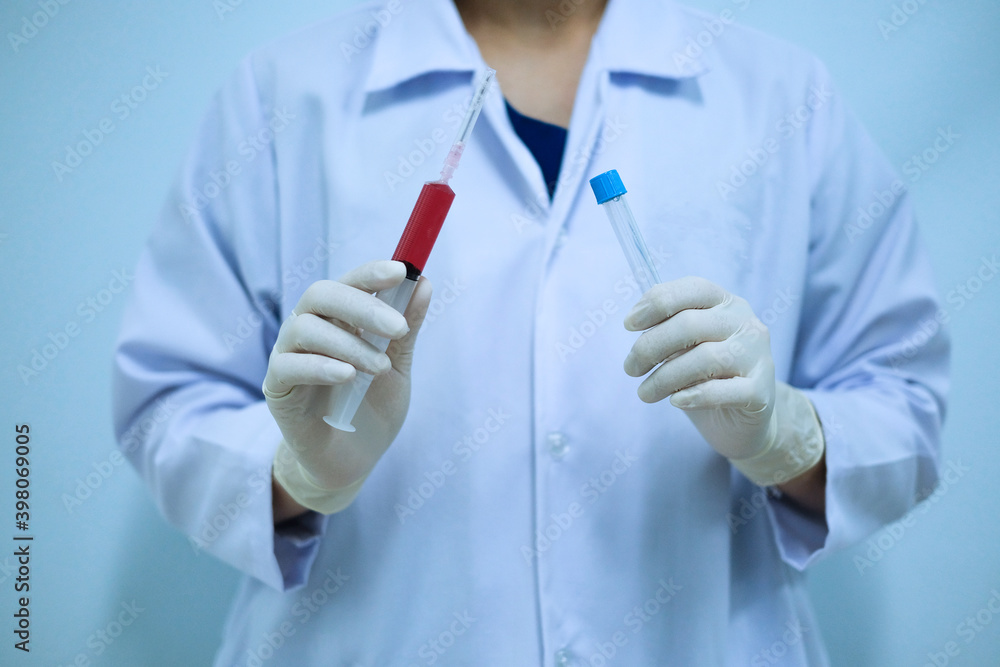 Medical technologist holding syringe and test tube Medical technologist holding syringe and test tube