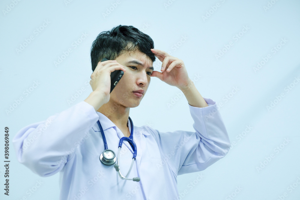 A male doctor talking telephone and holding document file A male doctor talking telephone and holding document file