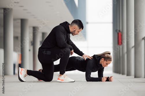 Female doing exercises, having personal trainer.