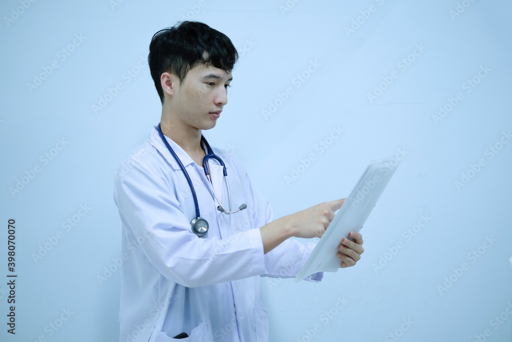 A male doctor reading patient's document file A male doctor reading patient's document file