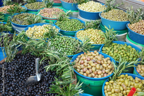 Olives assortment at outdoor market. Stall of colorful organic olives at farmers market. Healthy nutritious food.