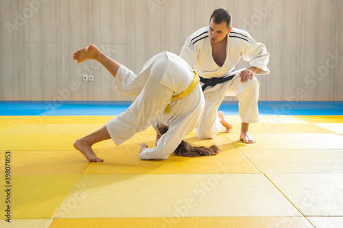 Judo master and young judo girl are training