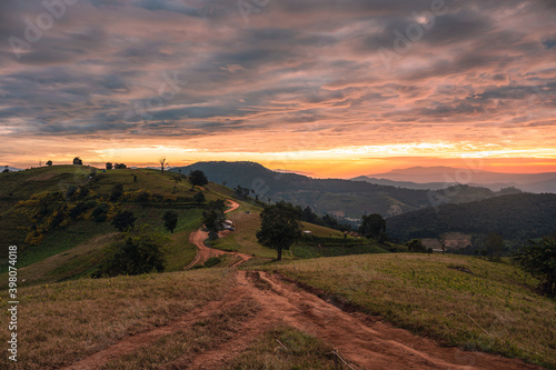 Sunrise on farmland hill with colorful sky and tourists camping on vacation in national park