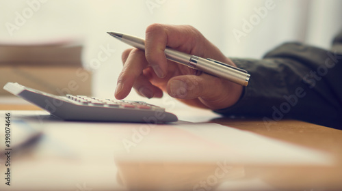 A MAN'S HAND OPERATING A CALCULATOR. CALCULATING. FINANCE