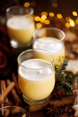 Homemade eggnog with creamy foam in a glass, a traditional Christmas drink close up view