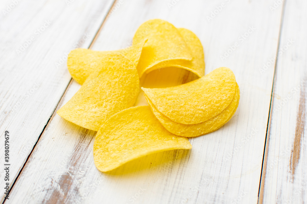 Potato chips on a white wooden background. Potato chips on a white wooden background.
