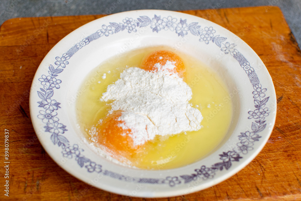 Flour with raw chicken eggs in a plate. Chop batter, frying. Flour with raw chicken eggs in a plate. Chop batter, frying.