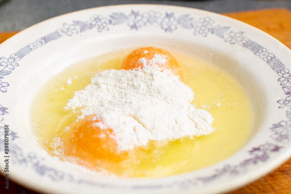 Flour with raw chicken eggs in a plate. Chop batter, frying. Flour with raw chicken eggs in a plate. Chop batter, frying.