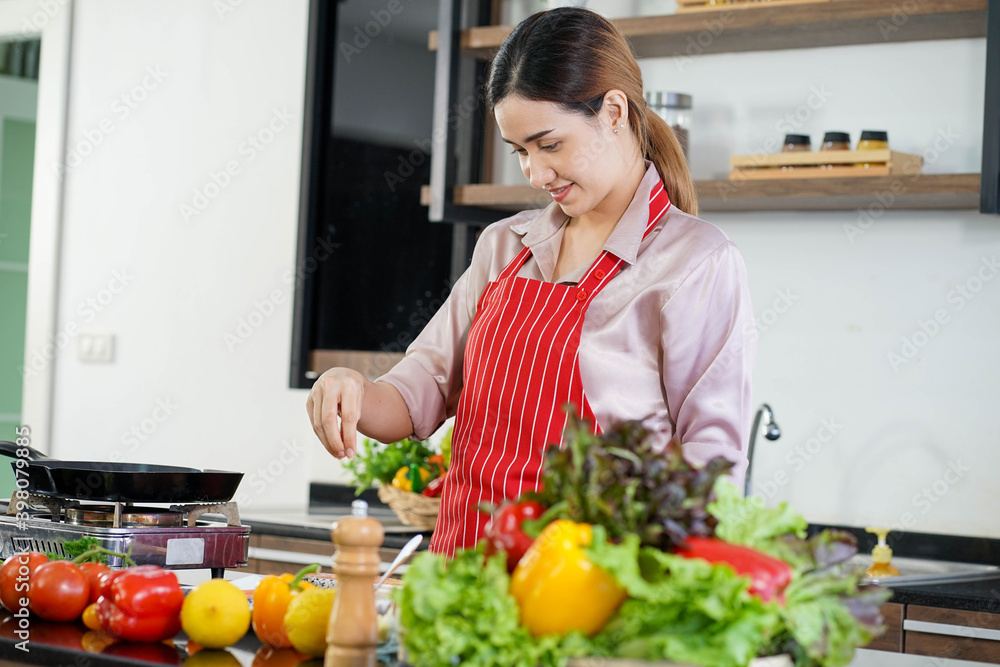 Asian beautiful woman wearing red apron teaching gourmet homemade recipe cooking online streaming vlogging work from home Asian beautiful woman wearing red apron teaching gourmet homemade recipe cooking online streaming vlogging work from home