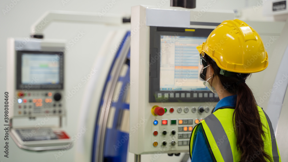 Female engineer checking machine operating system on control monitor. Female engineer checking machine operating system on control monitor.
