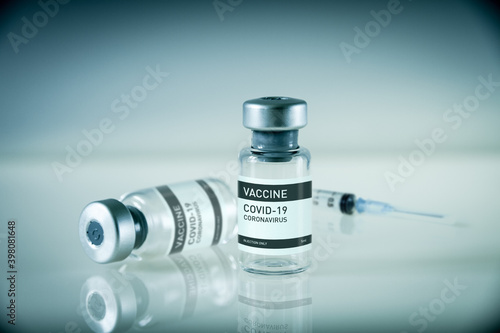 Covid-19 vaccine bottle and syringe on a blue background