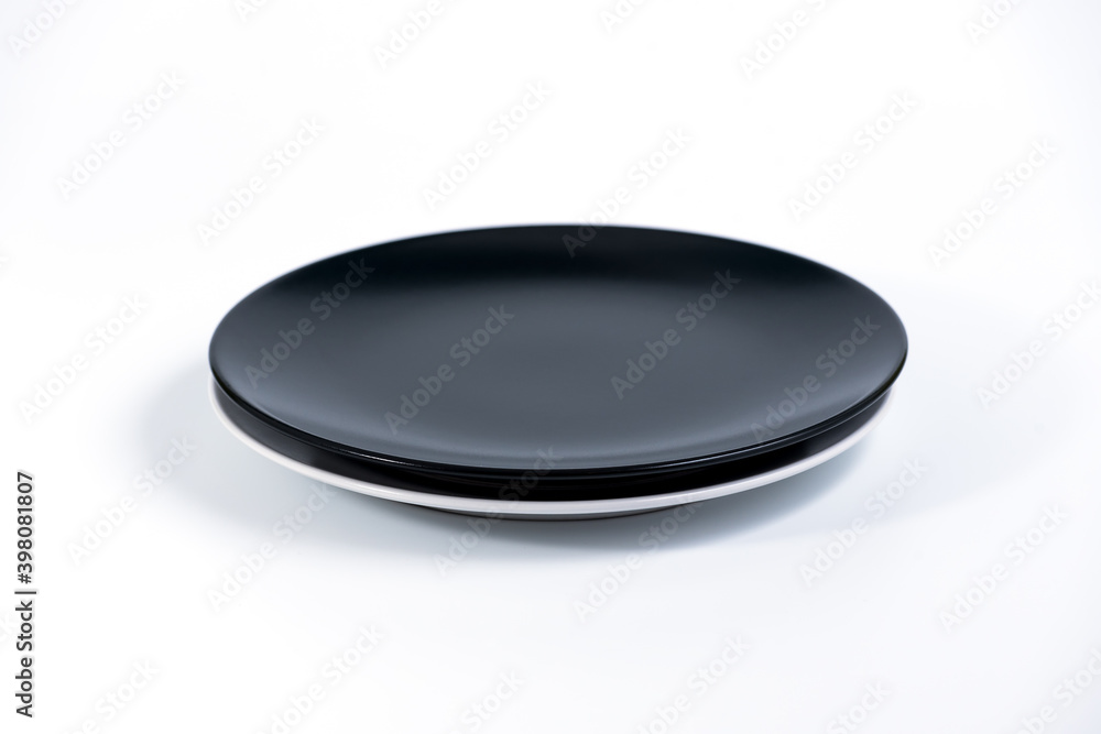 Empty Black and White plates stacked on white background side view Empty Black and White plates stacked on white background side view