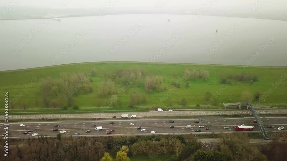 Drone shot view of busy motorway transport in nature close to a lake Drone shot view of busy motorway transport in nature close to a lake