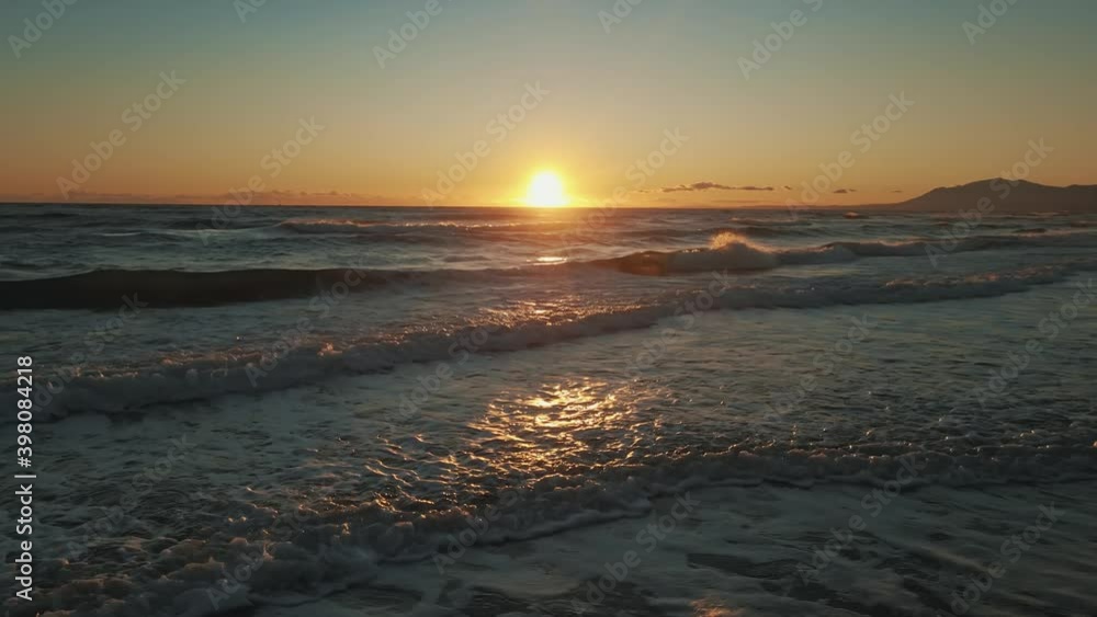 Ocean waves during sunset with a clear sky Ocean waves during sunset with a clear sky