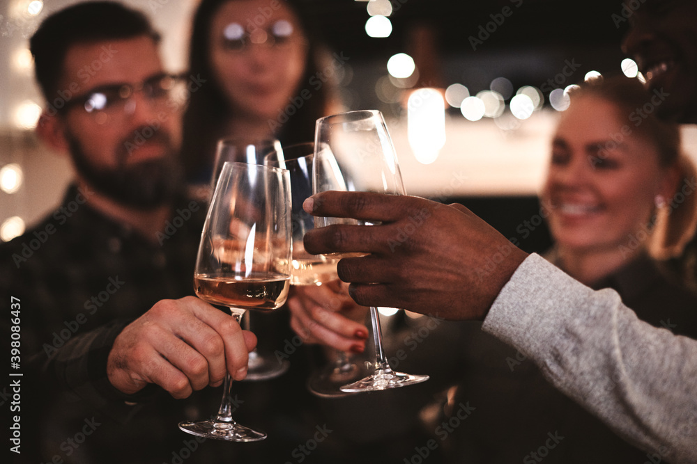 Diverse friends toasting with drinks during a dinner party