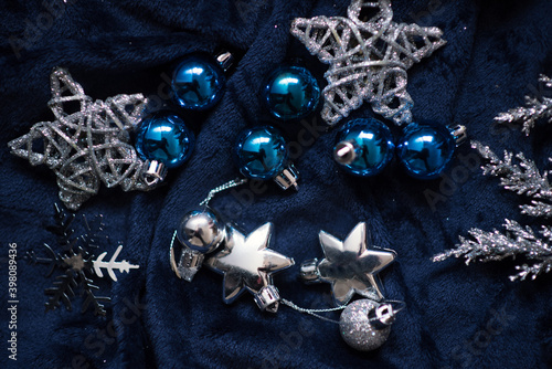 Fototapeta Naklejka Na Ścianę i Meble -  Christmas decoration on royal blue background. Top view on stars, wings and ornaments. 