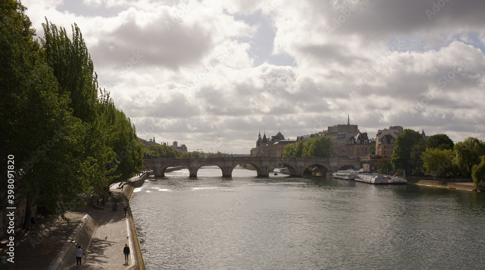 Naklejka premium View of the island of Site. Pedestrians on the embankments, ships sail on the Seine