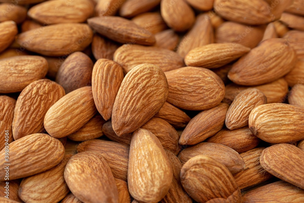 A lot of almonds nuts close-up. Natural background for healthy eating concept A lot of almonds nuts close-up. Natural background for healthy eating concept