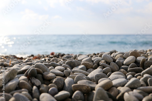 smooth pebbles stones on the beach with the sea on the background