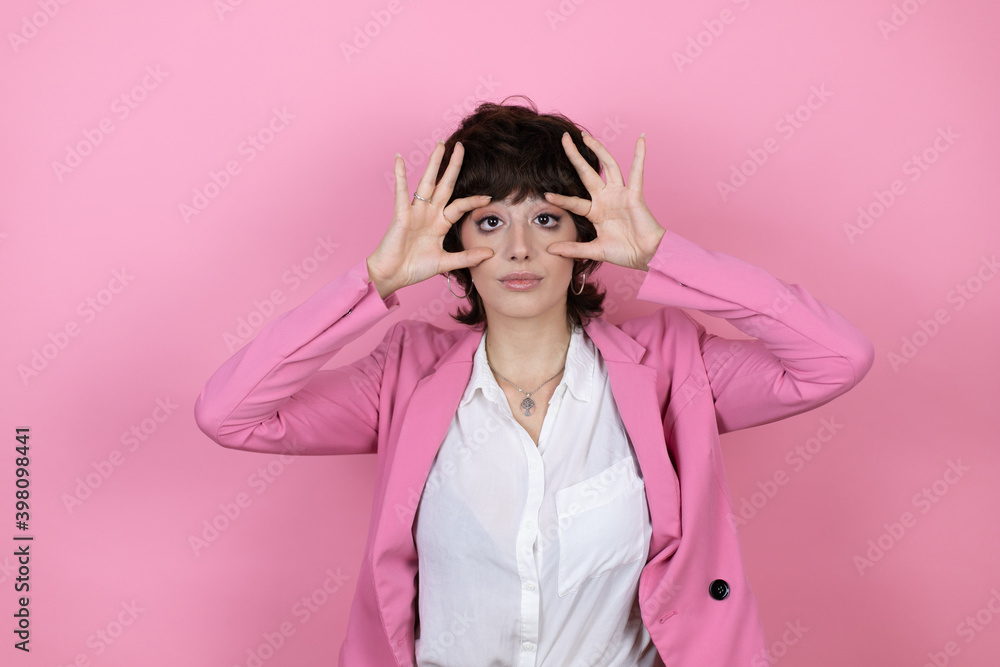 Young business woman over isolated pink background Trying to open eyes with fingers, sleepy and tired for morning fatigue Young business woman over isolated pink background Trying to open eyes with fingers, sleepy and tired for morning fatigue