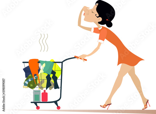 Woman with a trolley going to wash dirty laundry. Young woman moves a trolley with dirty laundry and holds her nose from odor nuisance isolated on white

